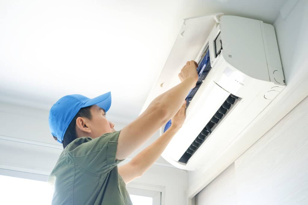 Male repair air conditioner at room, He is air technician , mechanic , engineer. Maintenance air conditioner myself.